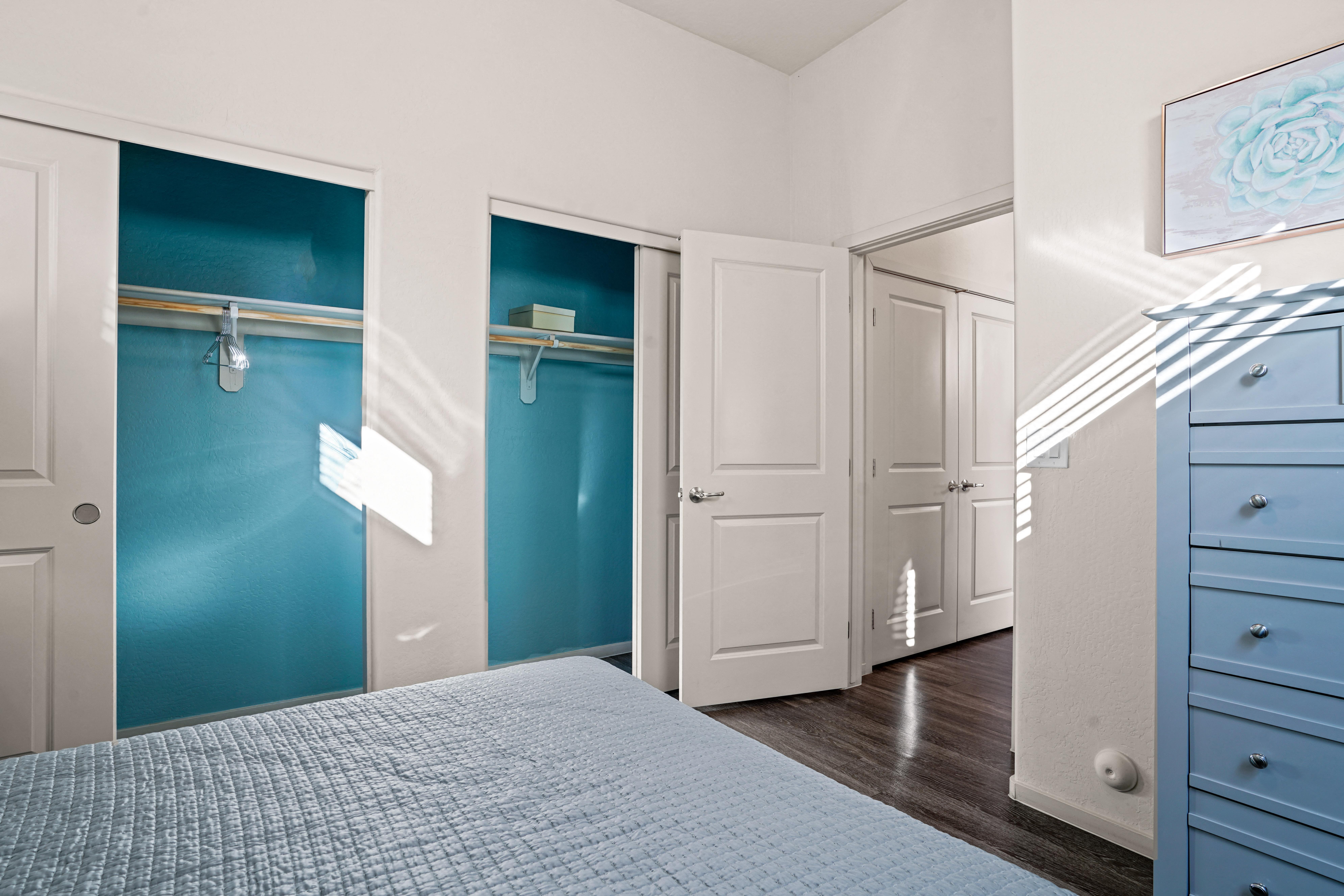 a bedroom with blue closets and white doors and a bed at Olive Queen Creek Apartments, Queen Creek, AZ, 85142